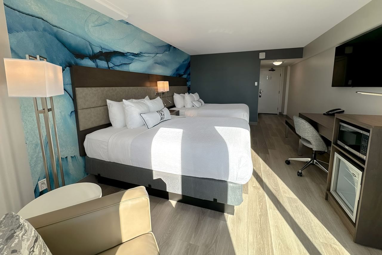 Hotel guestroom with king bed and a blue wall mural