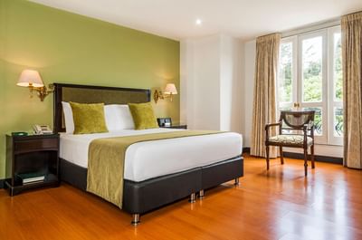 King bed, nightstands & chair in Junior Suite at Le Manoir Bogotá Hotel