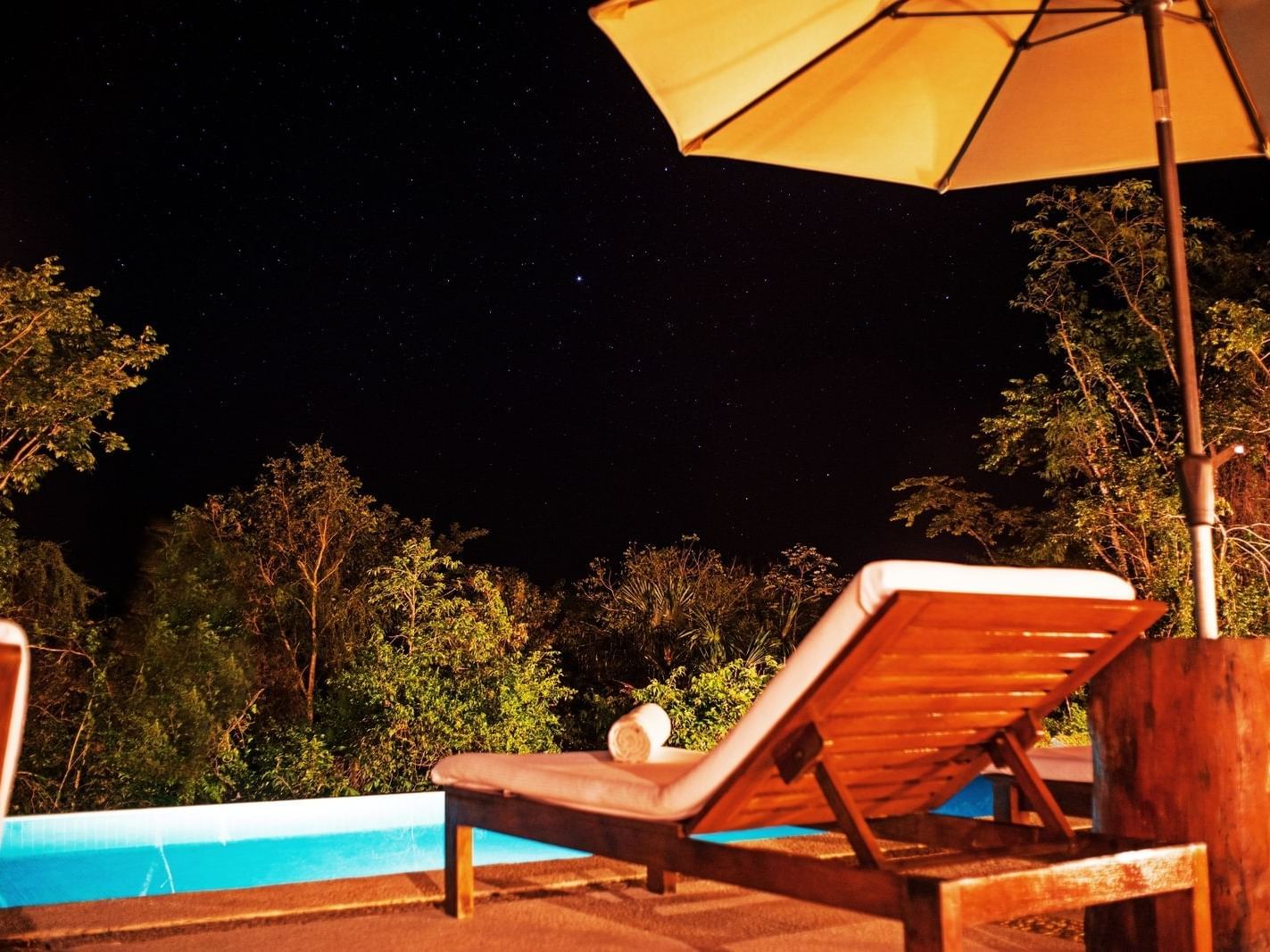 Sun lounger at pool at night at La Coleccion Resorts