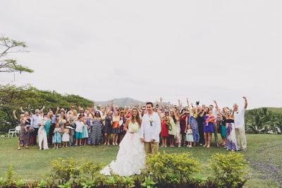 A wedding couple with guests cheering outdoors at Musket Cove Island Resort & Marina