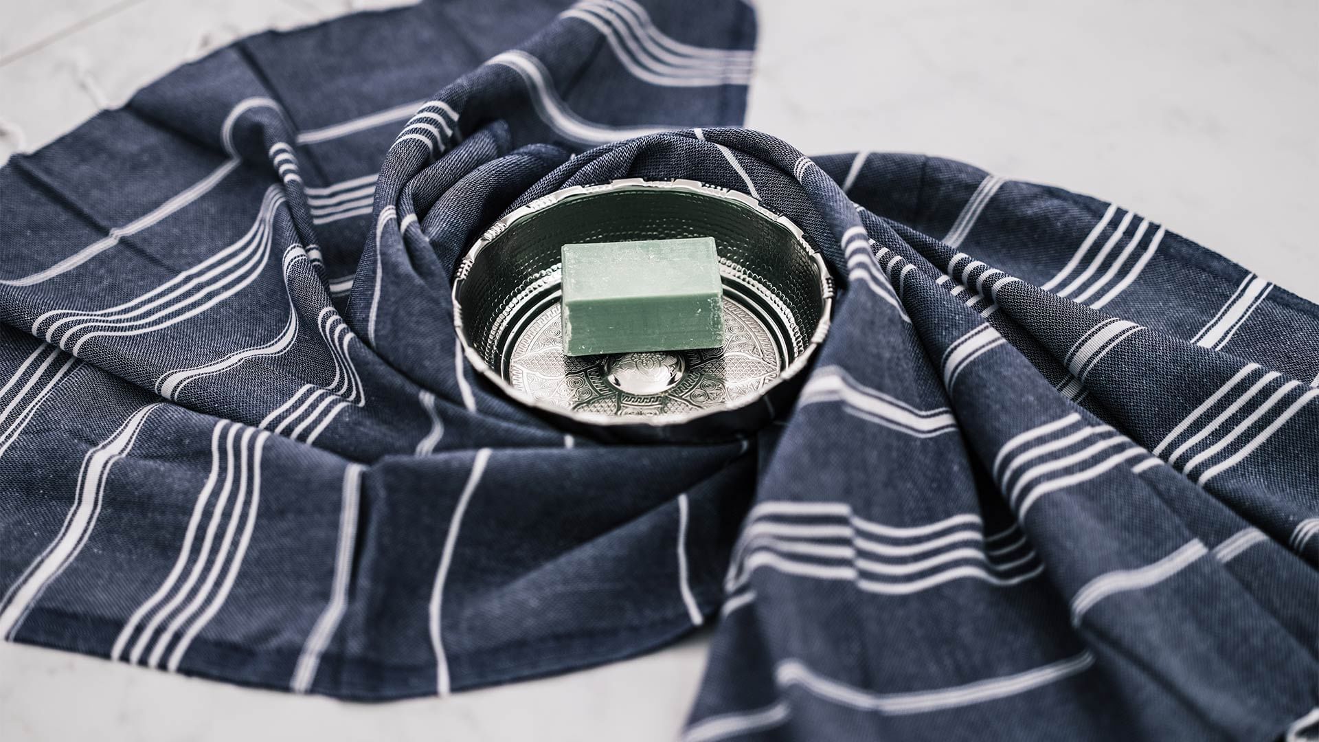 Soap bar on a silver decorative dish, wrapped in a navy cloth at Falkensteiner Hotel & Spa Jesolo