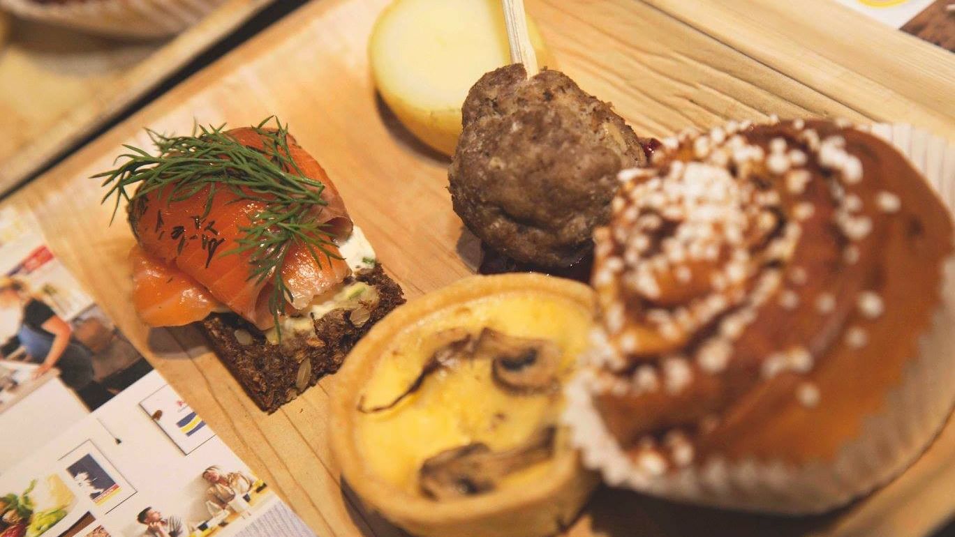 Delicious small bites on a wooden tray under warm lighting in Fika Cafe at Elysium Manly, a top-choice hotel in Manly