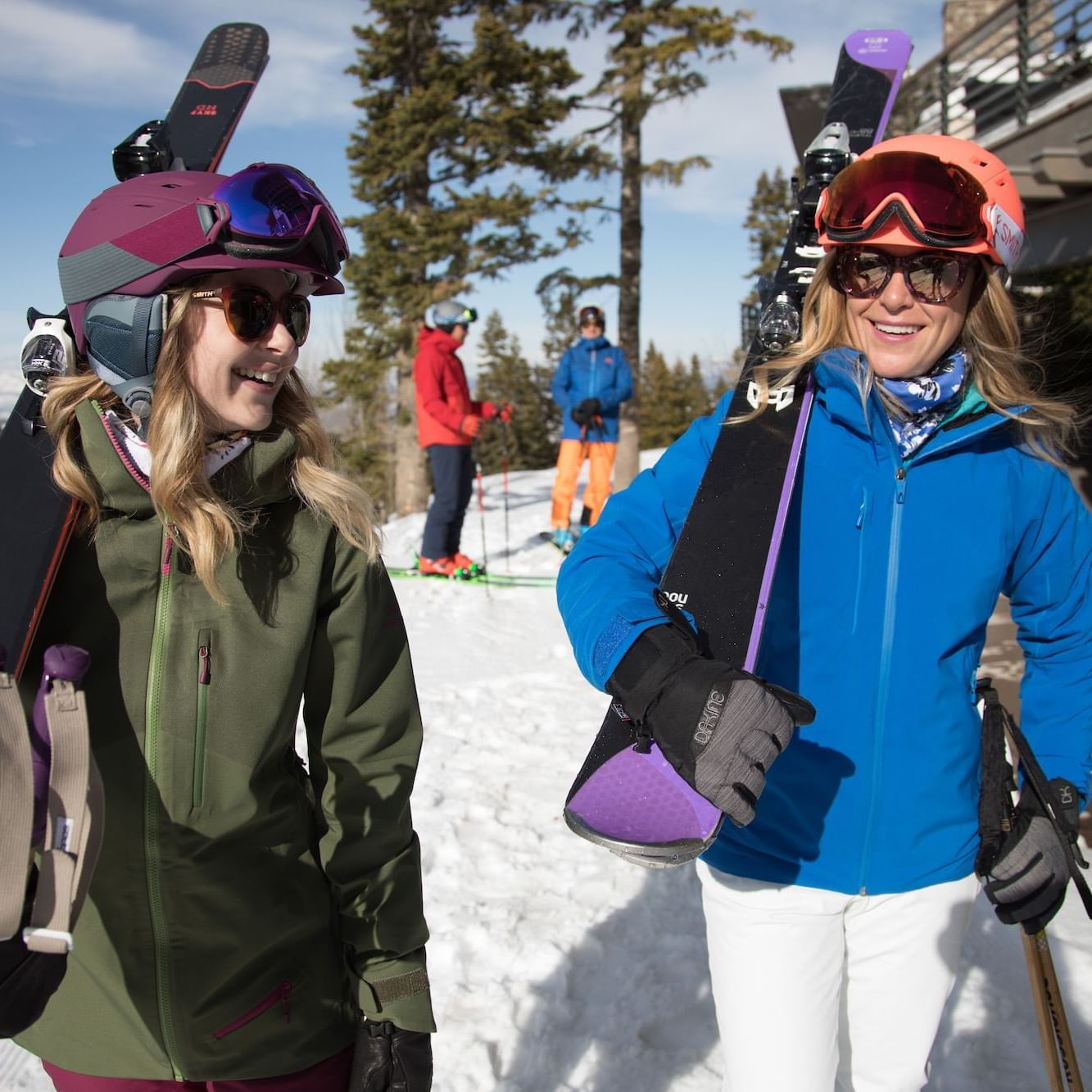 Friends carrying skis on a bluebird day