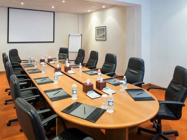 A long table setup for a meeting in Masfout room at Ajman Hotel