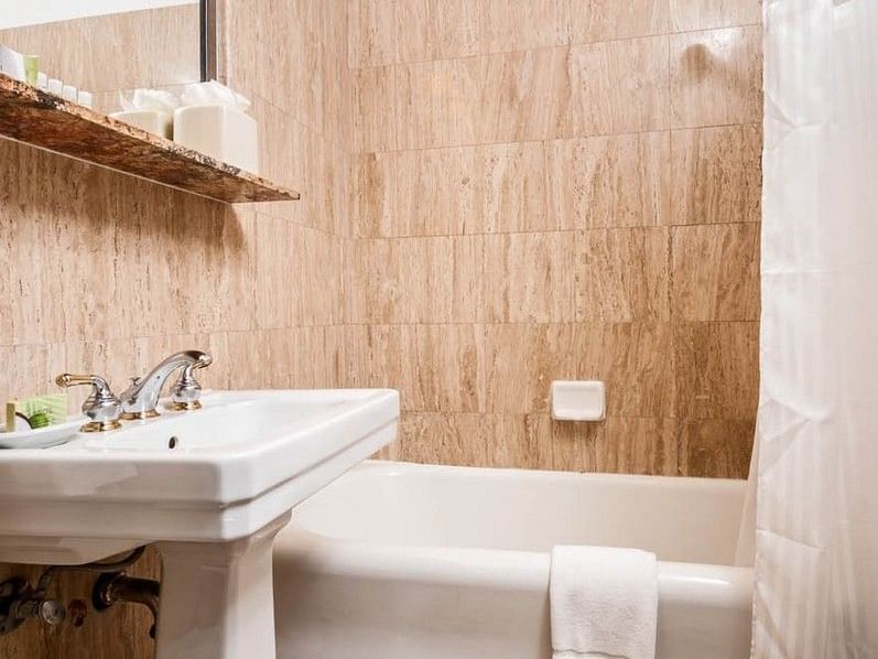 White sink, bathtub, and toilet in a tiled bathroom at Pickwick San Francisco.