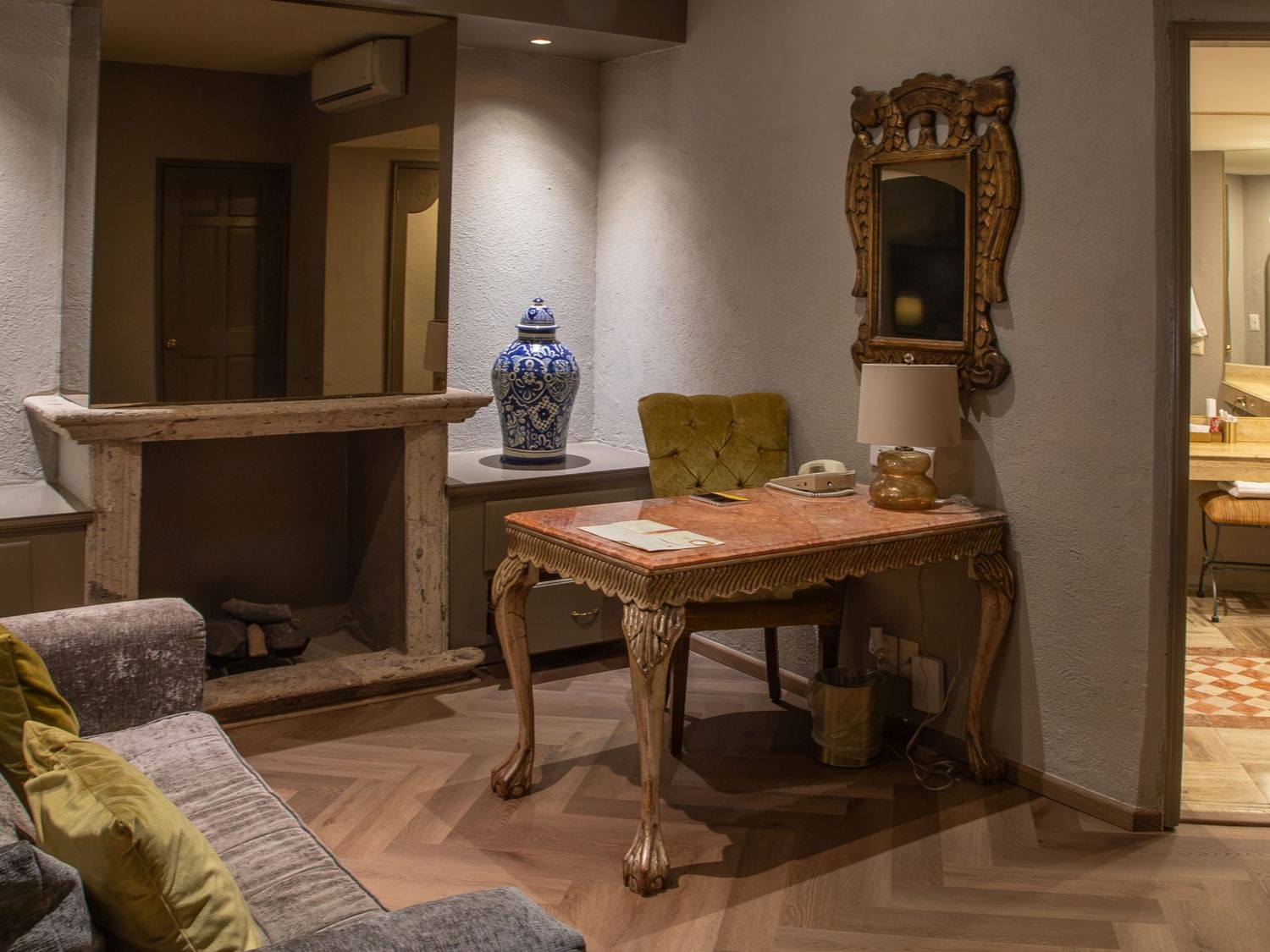 Área de estar con escritorio antiguo, chimenea y baño en suite en la Master Suite King de Quinta Real Guadalajara