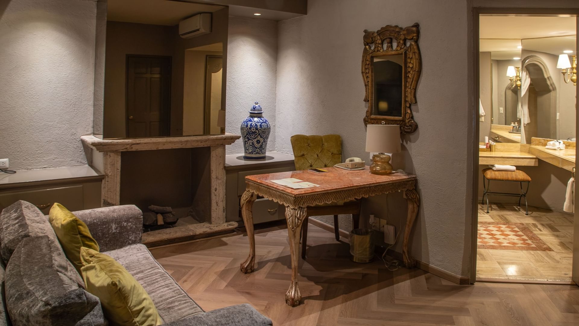 Área de estar con escritorio antiguo, chimenea y baño en suite en la Master Suite King de Quinta Real Guadalajara