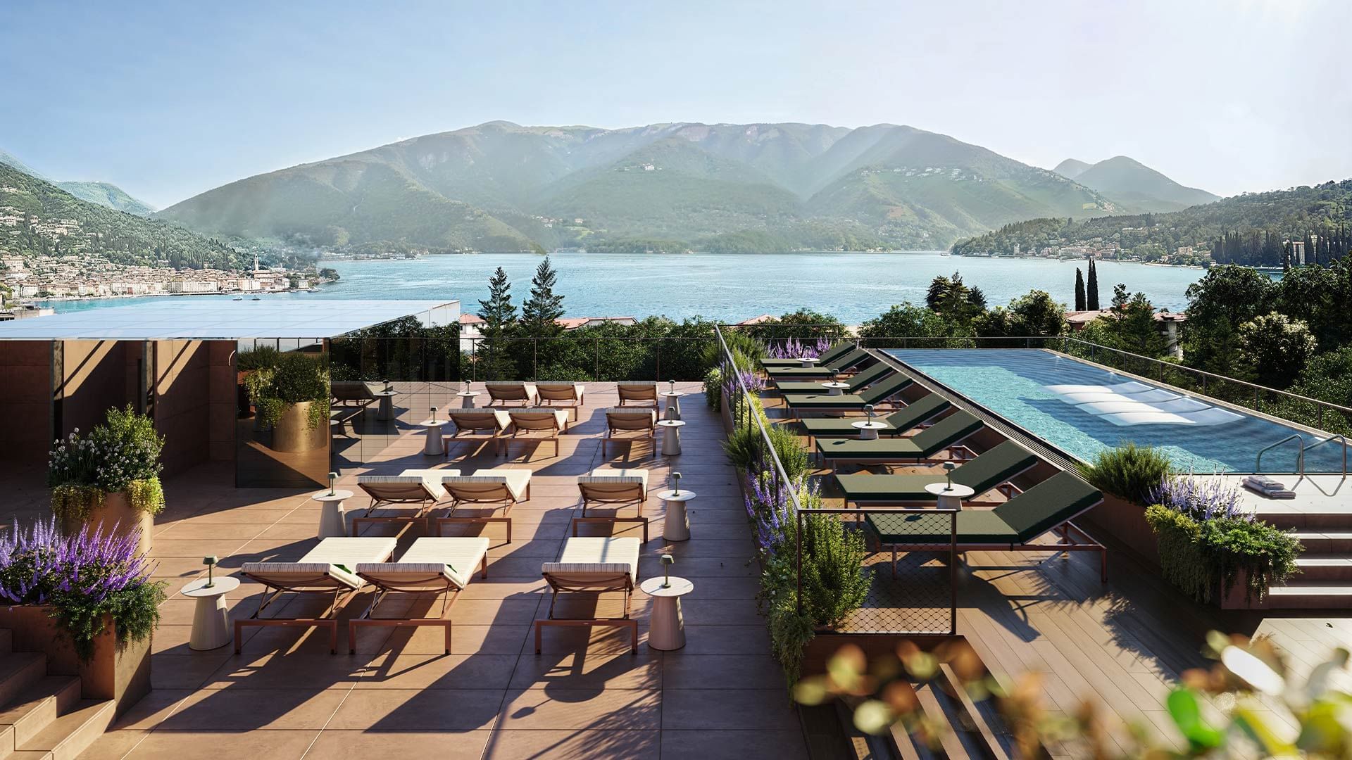 Outdoor rooftop lounge with lounge chairs, pool, and scenic mountain and lake view.