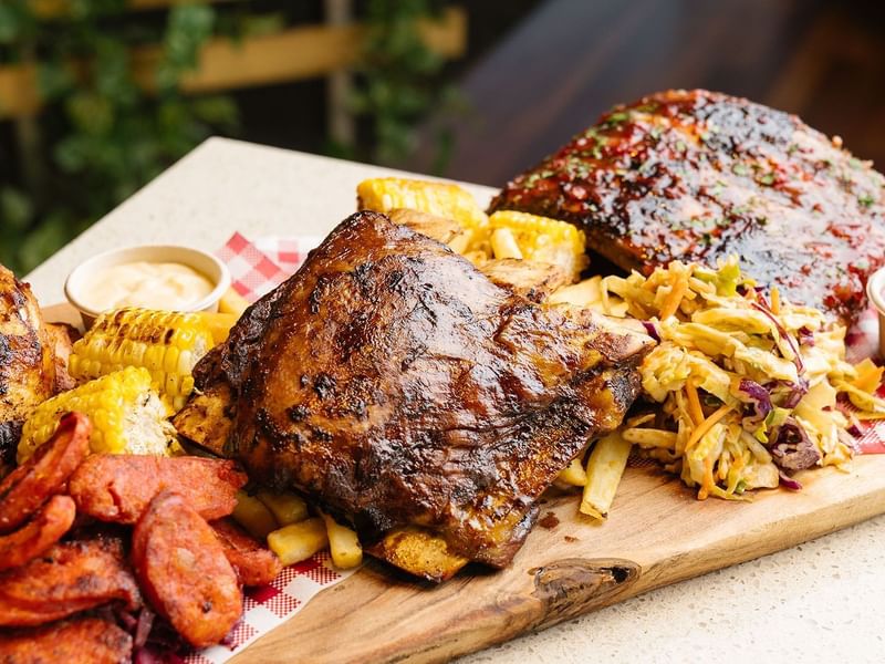 BBQ ribs with corn, coleslaw, fries & sauce in a restaurant at Crown Hotels