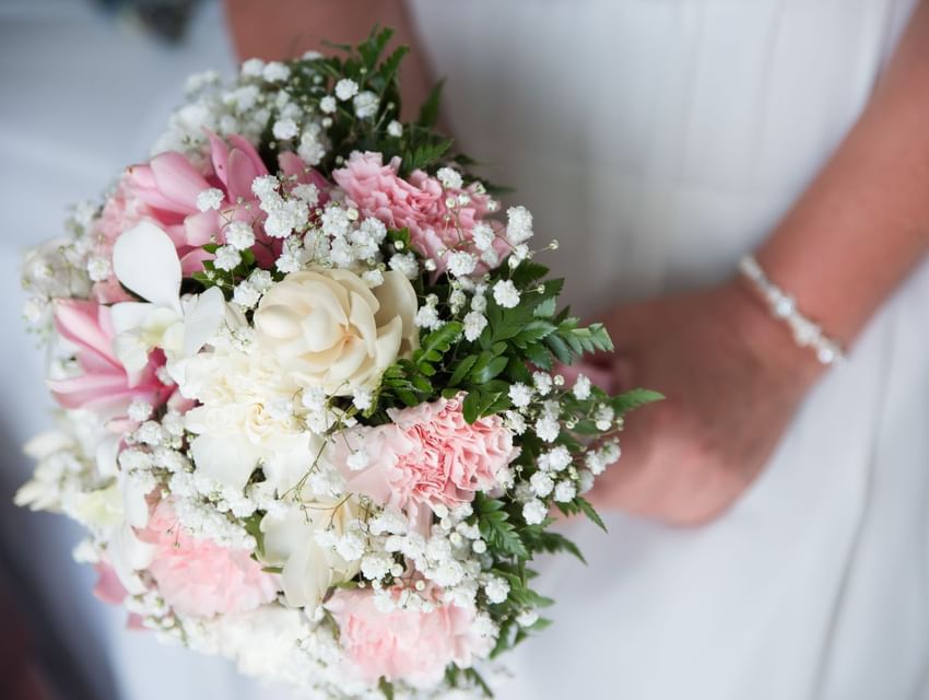 Close-up of a bride holding a bouquet at Bay Gardens Hotels and Resorts