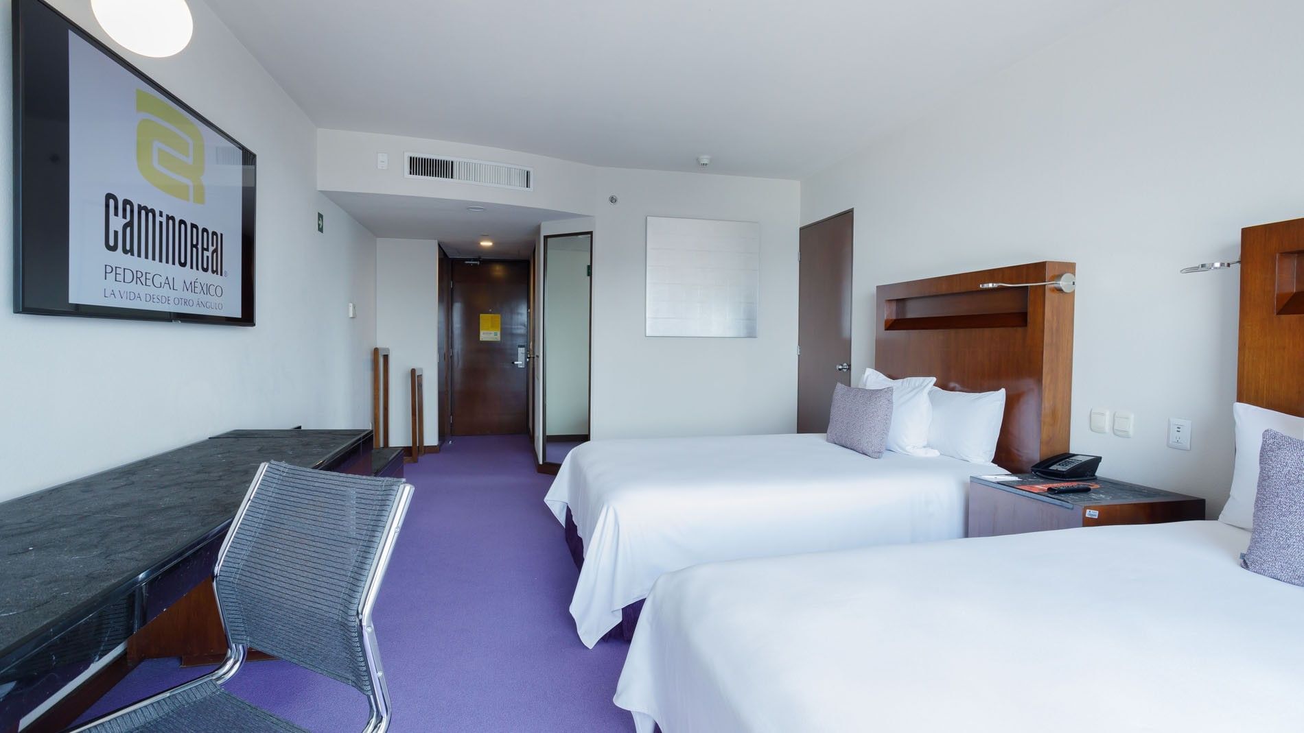 Clean 2 Double Deluxe interior with purple flooring and a wall-mounted TV at Camino Real Pedregal Mexico