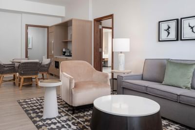 Lounge area with plush seating and small kitchenette area in Kai Ocean View Ali'i Suite at the Maui Coast Hotel