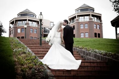 Wedded couple kissing on the stairway at Amora Hotel Melbourne