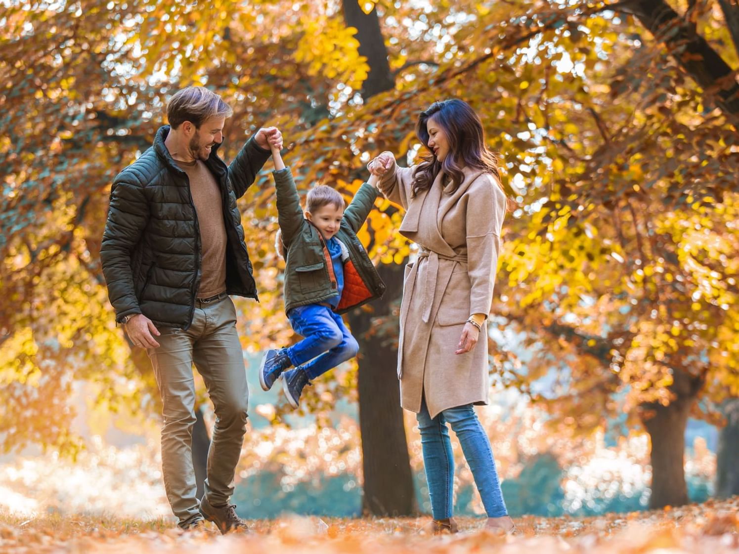 Kid enjoying with his parents outside at The Originals Hotels