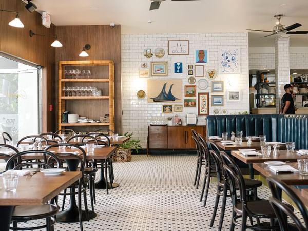 Indoor image of the restaurant with a wall of art pieces, a ceil