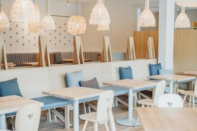 Dining area with wooden tables and chandeliers at The Stonebreaker Hotel