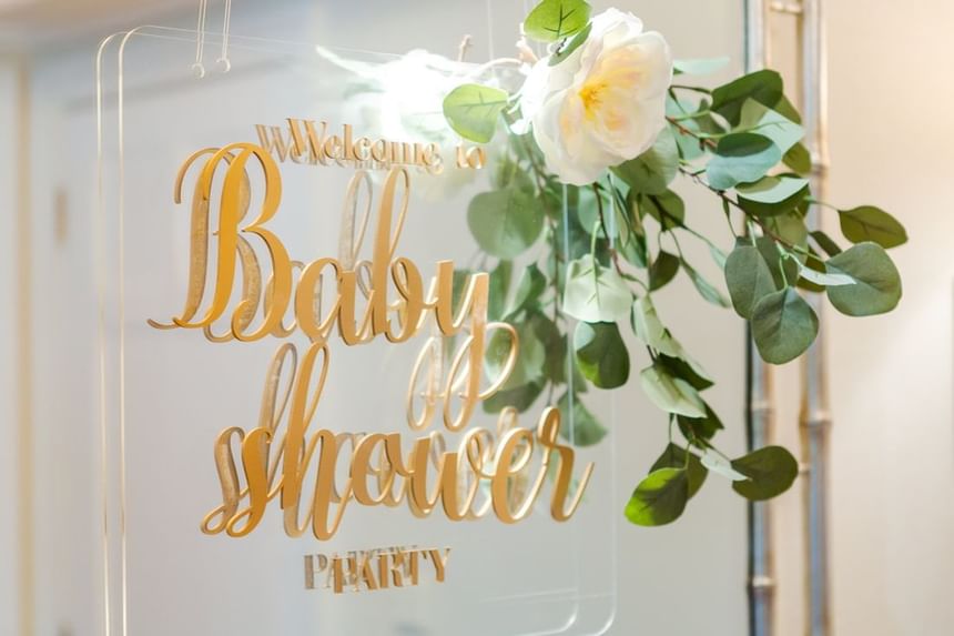 Decorative sign that reads Welcome to Baby Shower Party in gold cursive letters at Park Hyatt Saigon