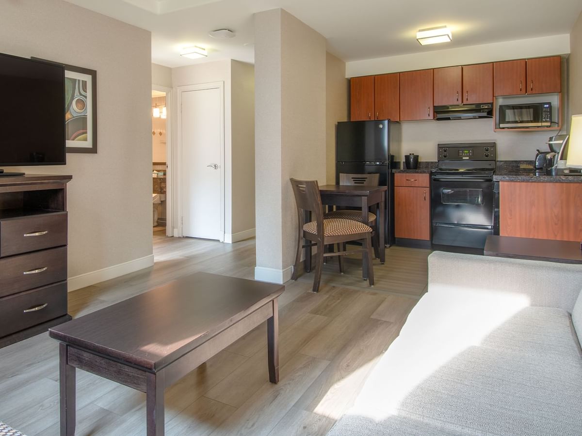 Hotel suite with TV, living area, kitchen area with fridge, microwave and coffee machine