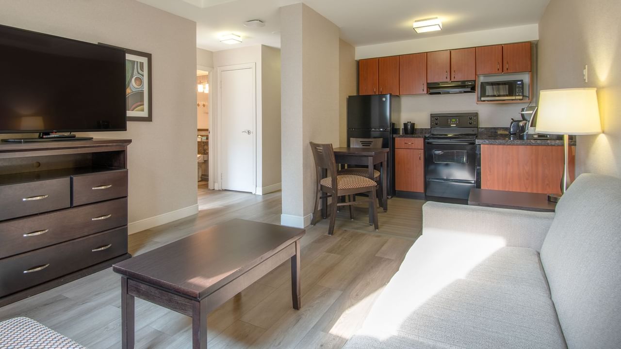 Hotel suite with TV, living area, kitchen area with fridge, microwave and coffee machine