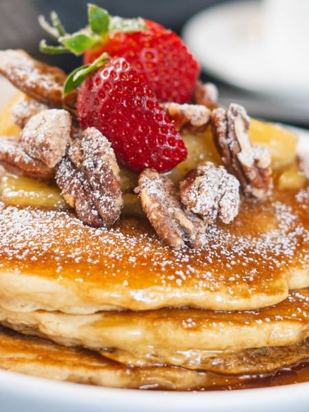 Pancakes with pecans and strawberries under powdered sugar in The Landmark - Breakfast at Warwick Melrose Dallas