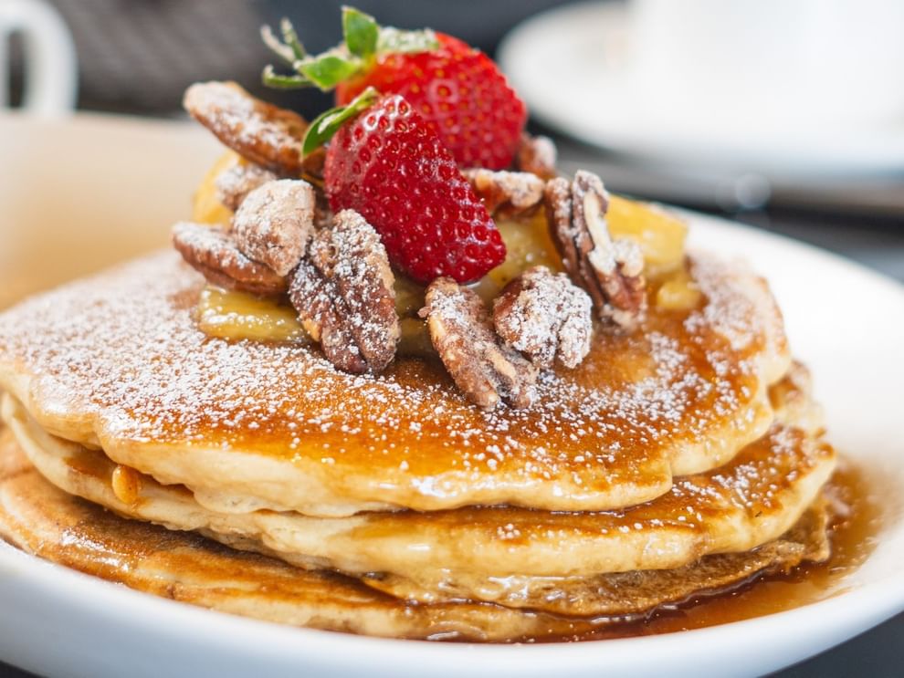 Pancakes with pecans and strawberries under powdered sugar in The Landmark - Breakfast at Warwick Melrose Dallas