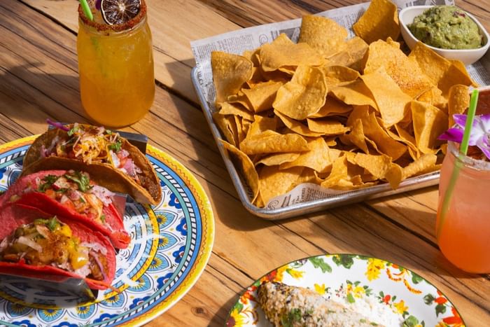 Delicious spread of tacos and nachos paired with refreshing cocktails at Taco Taco near Riviera Hotel South Beach