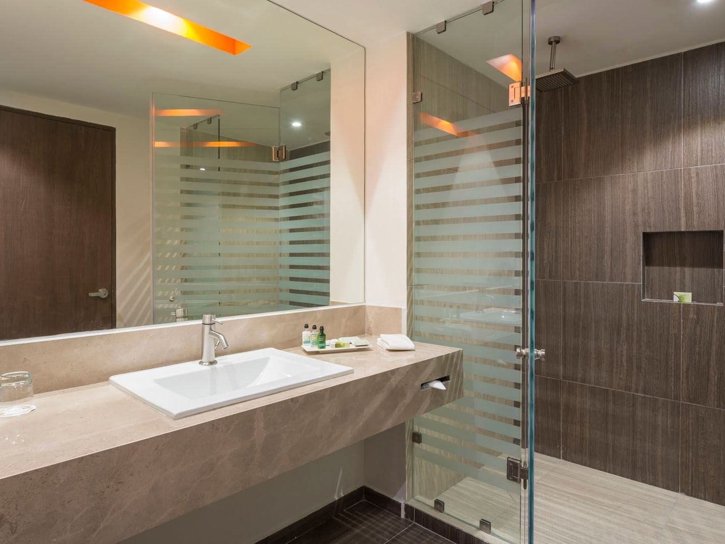 King Superior bathroom featuring a marble vanity, large mirror, and a glass-enclosed walk-in shower at Real Inn Celaya