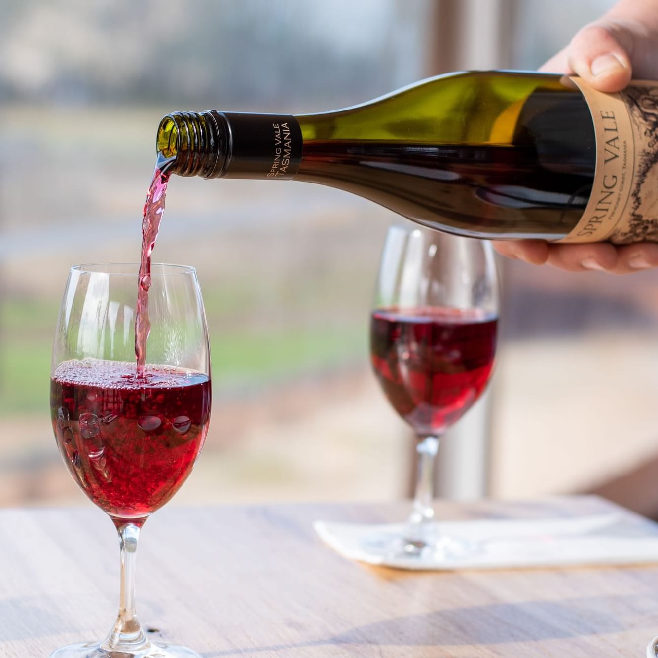 A person pouring red wine into glasses at Freycinet Lodge