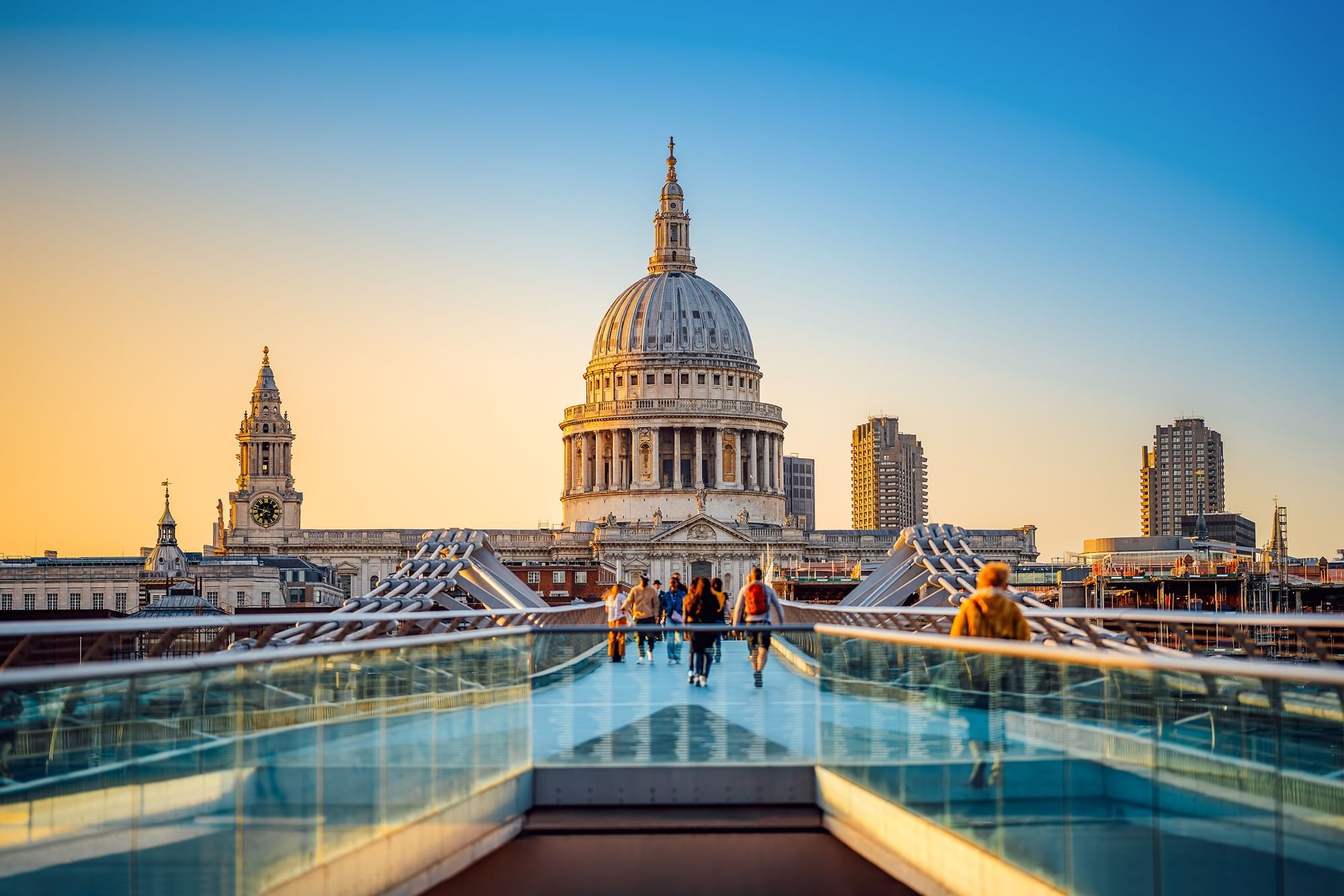 Pedestrians crossing Bridge over River Thames with St Paul’s Cathedral dome near The Capital Hotel, Apartments and Townhouse