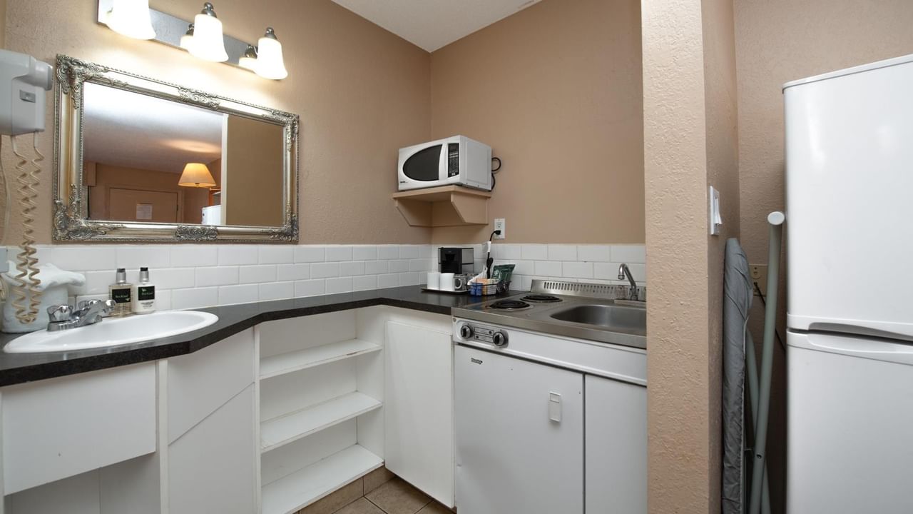 Kitchenette at Coast Red Deer Hotel with sink, microwave and full-size fridge