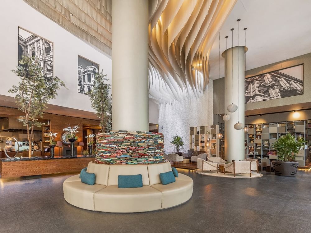 Hotel lobby with comfy seating, indoor plants, shelves & decor at Live Aqua Resorts and Residence Club