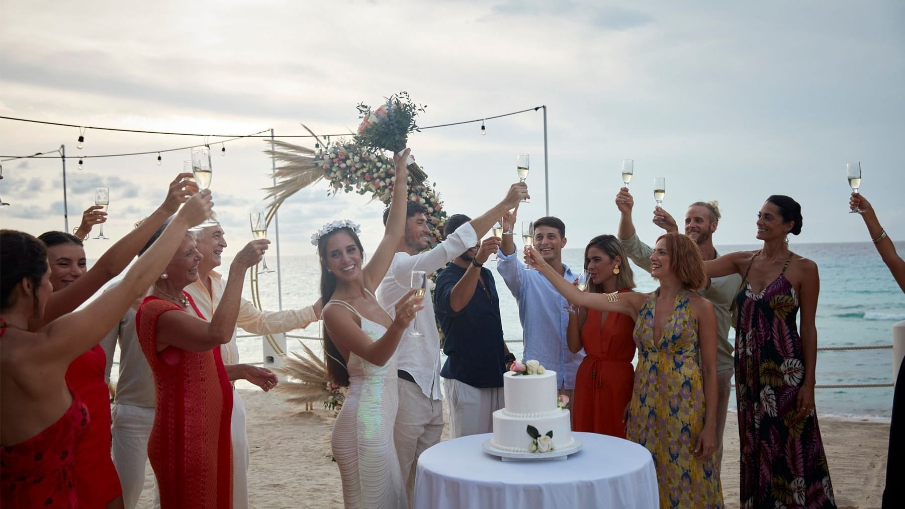 A group of people celebrating with the wedding couple while holding drinks at Grand Fiesta Americana