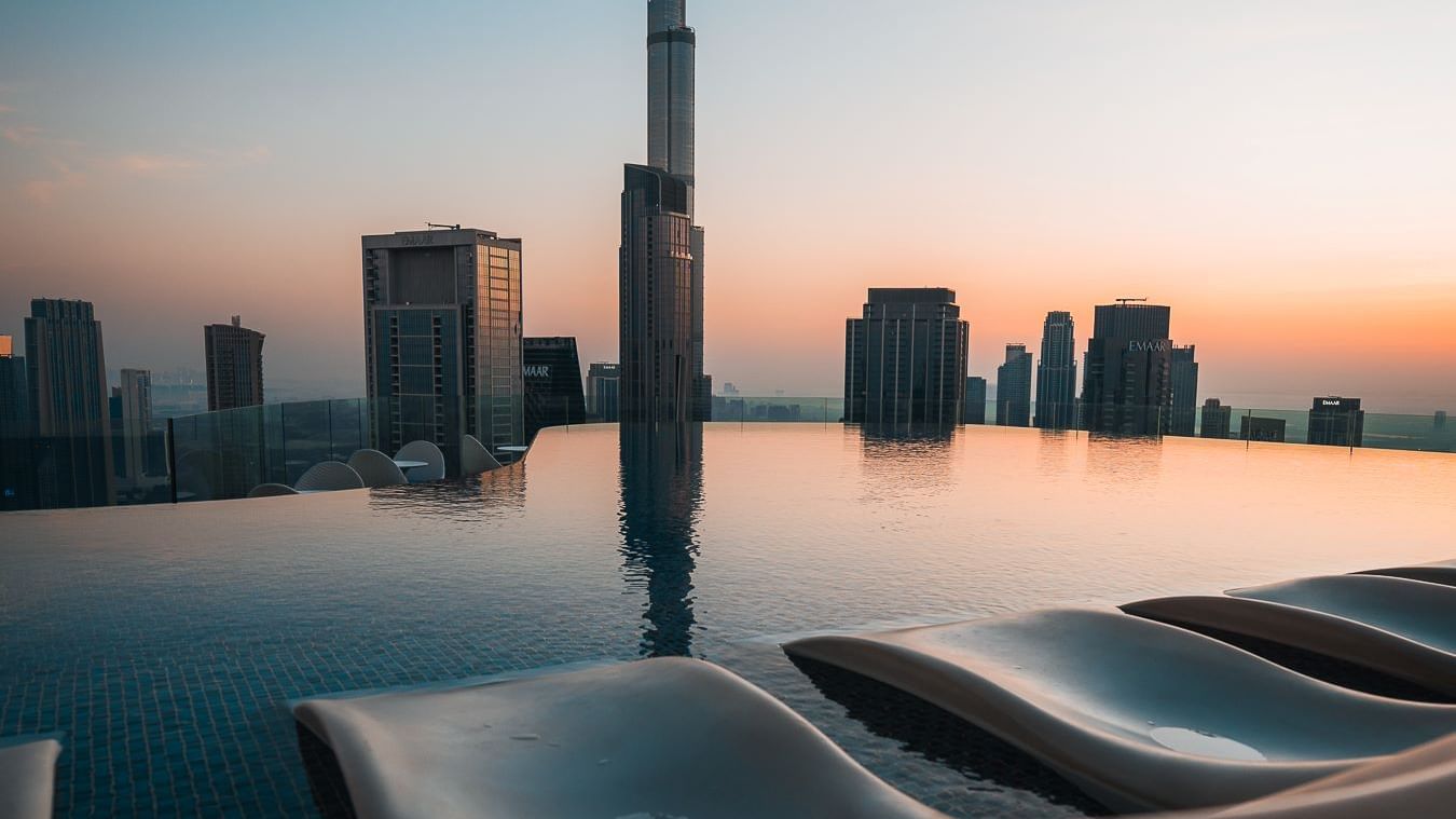 Relaxing rooftop infinity pool at Paramount Hotel Midtown, overlooking a stunning skyline and the Burj Khalifa