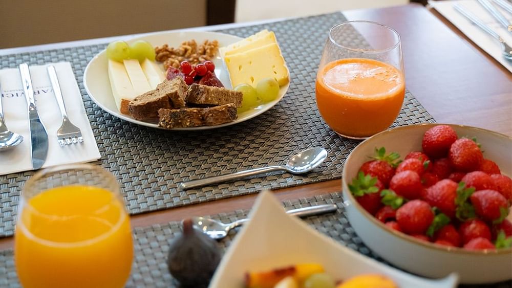 Un délicieux plateau de fruits frais et de fromages pour le petit-déjeuner chez Warwick Hotels and Resorts, accompagné de jus d'orange