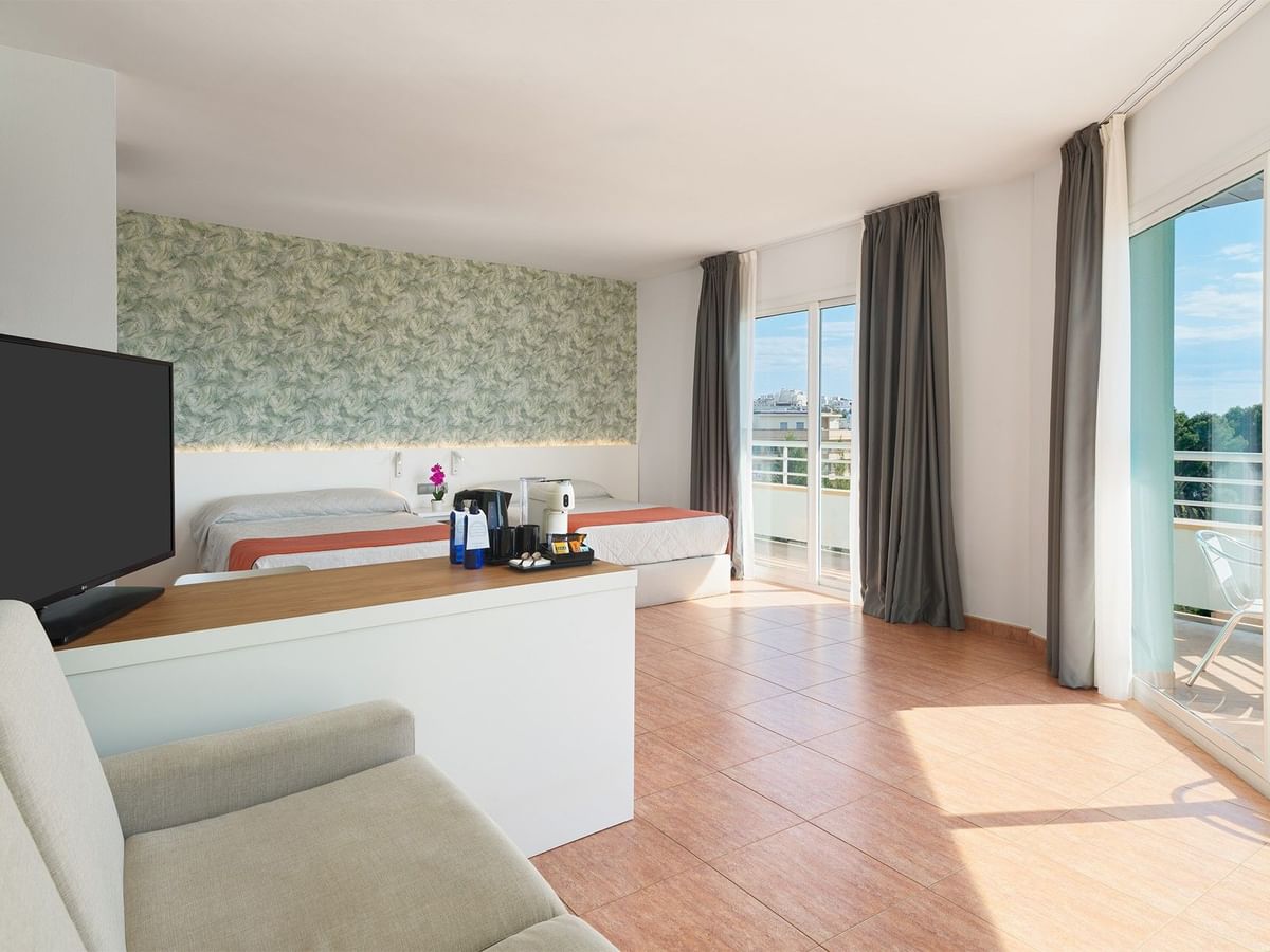 Comfy twin beds, TV and sofa in Junior Suite Rooms at Ponient Pirámide Salou