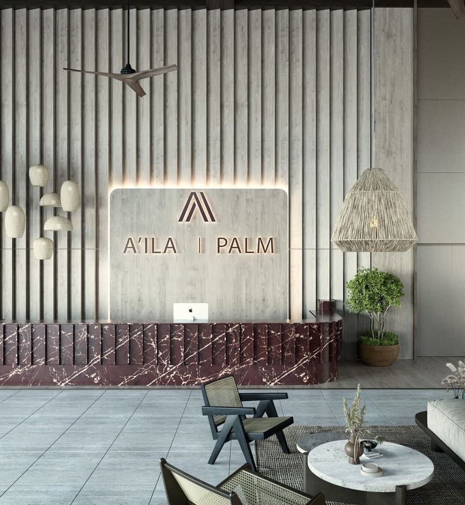 Luxurious front desk and lobby at A'ila Resorts, with a marble counter, modern decor, and plush seating