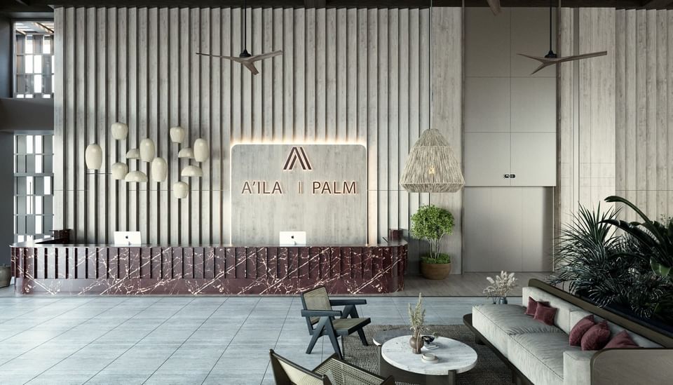Luxurious front desk and lobby at A'ila Resorts, with a marble counter, modern decor, and plush seating