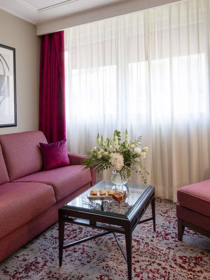 Chambre Executive avec grand lit, coin salon et fenêtre à l'hôtel Warwick Champs-Élysées à Paris.