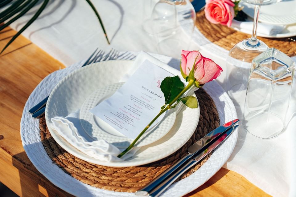 Plate, rose, and napkin on table at SafiraBlu Luxury Resort