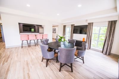 dining area with tables and chairs, counter with chairs, and two