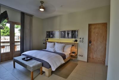 Bed by the windows with wall-mounted artworks and tile flooring in Terrace Executive Suite at Billini Hotel Historic Luxury