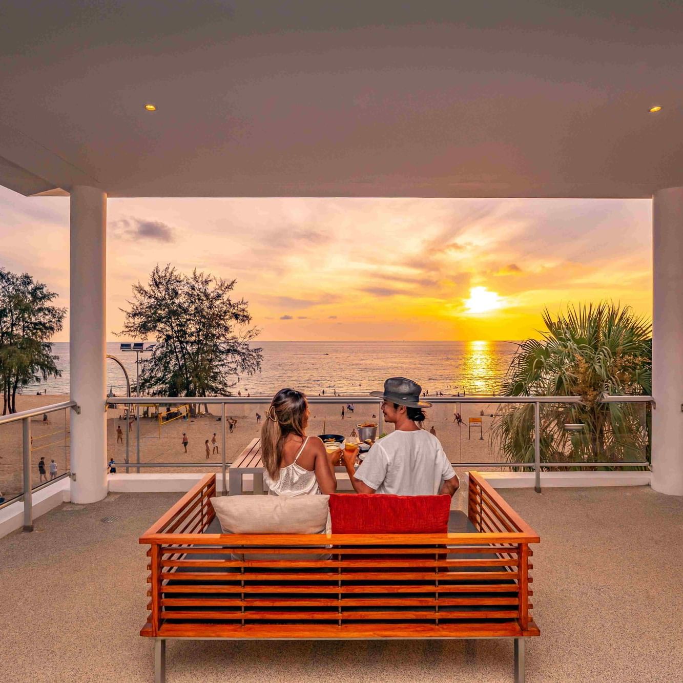 A couple is having a romantic dinner with the sunset view at Family Two - Bedroom Beachfront Residence