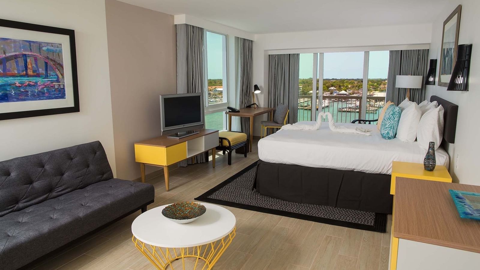 Grey sofa by a round table under soft ceiling lights in Harbour Premium Balcony at Warwick Paradise Island Bahamas