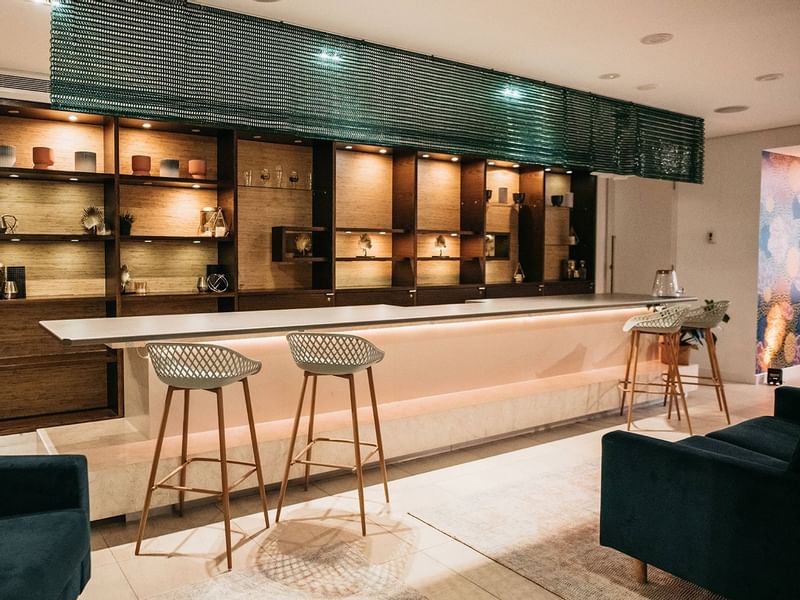Bar area with stools, shelves, and ambient lighting in Temple Lounge at Pullman Port Douglas