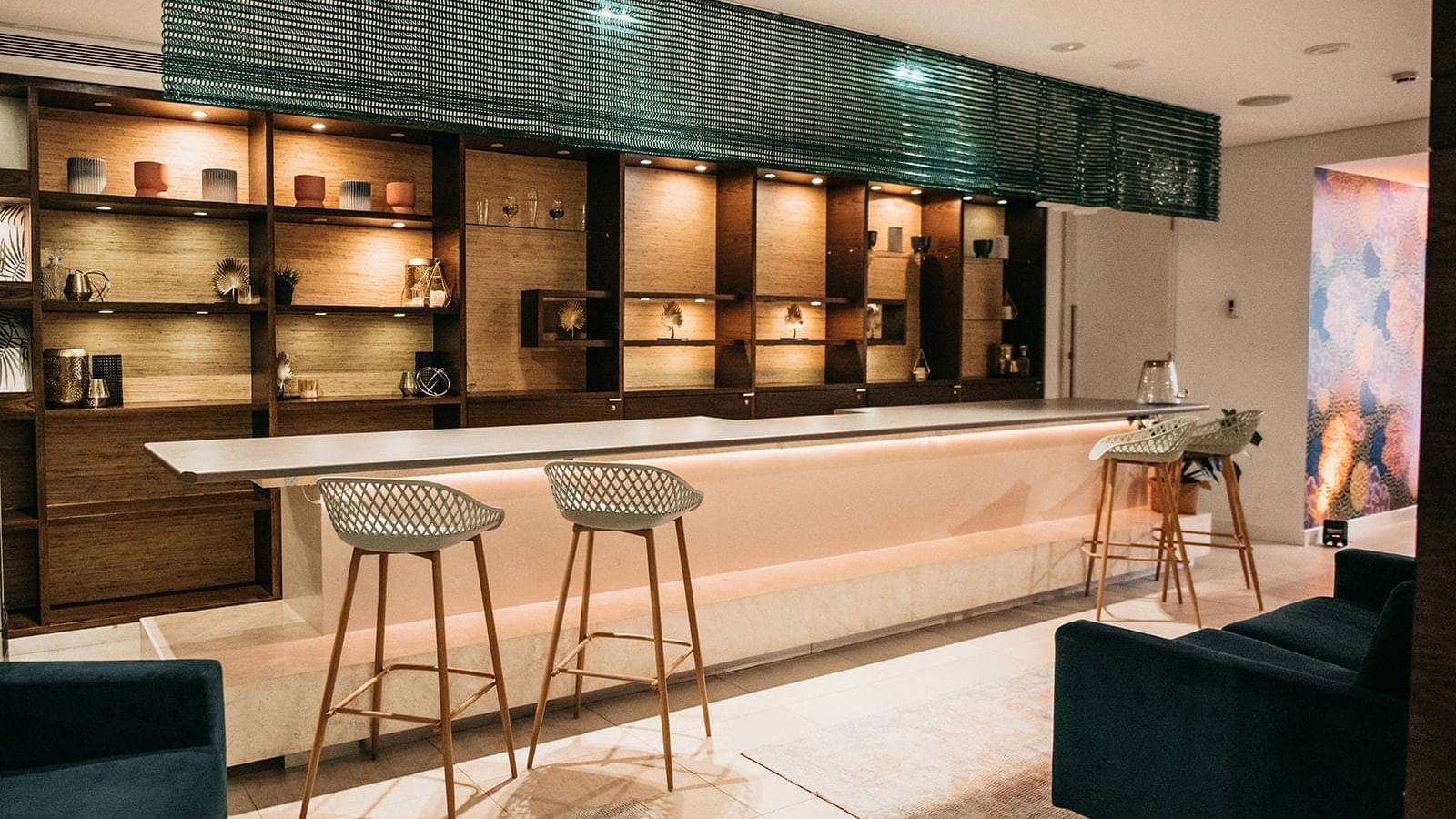 Bar area with stools, shelves, and ambient lighting in Temple Lounge at Pullman Port Douglas