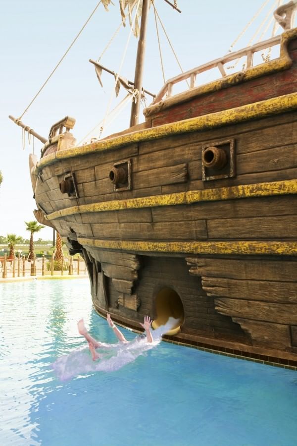 Lady sliding out of a water slide into a pool at Lake Buena Vista Resort Village & Spa