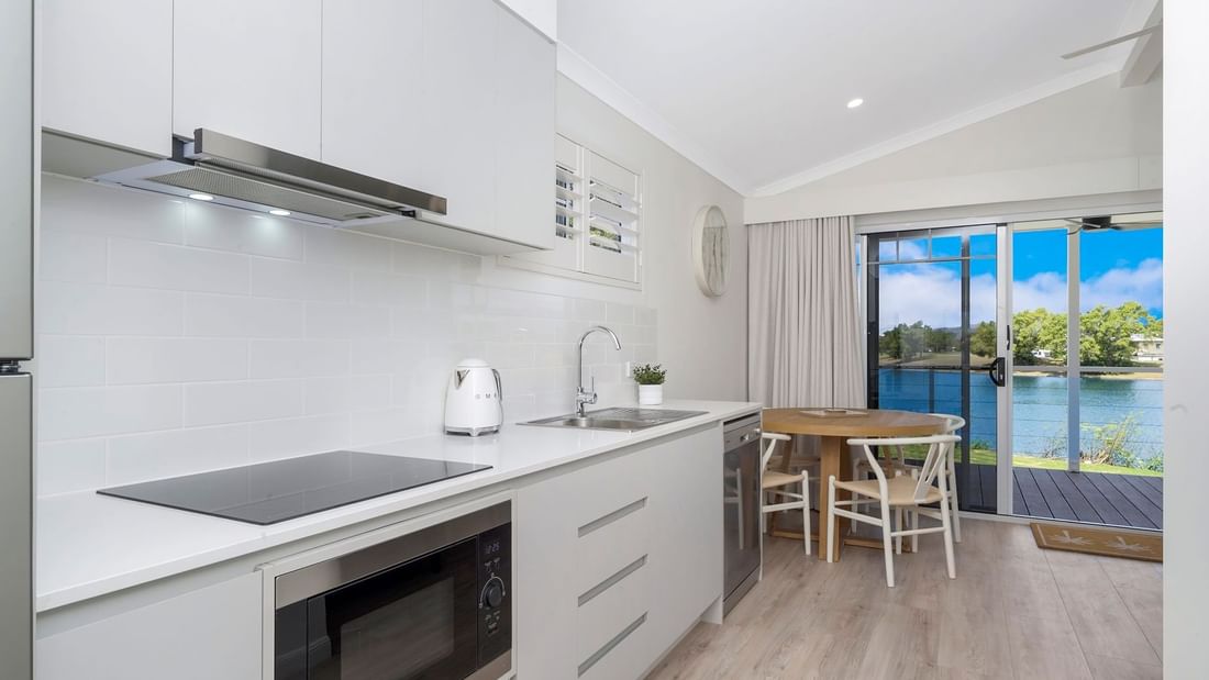 Deluxe Bungalow 2 Bedroom kitchen with sleek cabinetry, appliances, and a dining table at Mercure Hotel Townsville