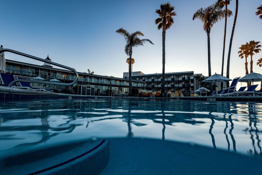 Blue pool water and palm trees at hotel 