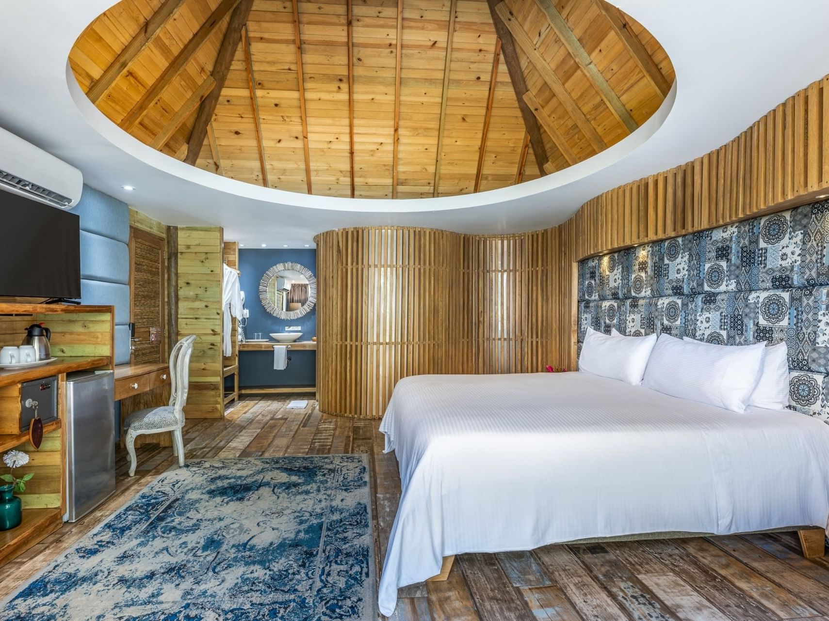 Comfy bed, TV, work table and bathroom vanity in Master Suite at Hotel Isla Del Encanto