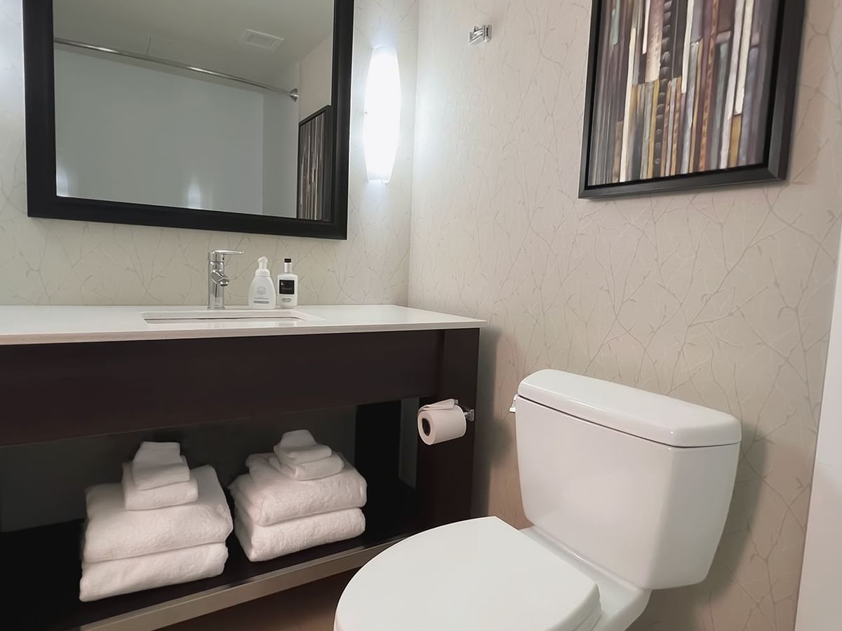 Bathroom with towels, toilet, mirror, sink